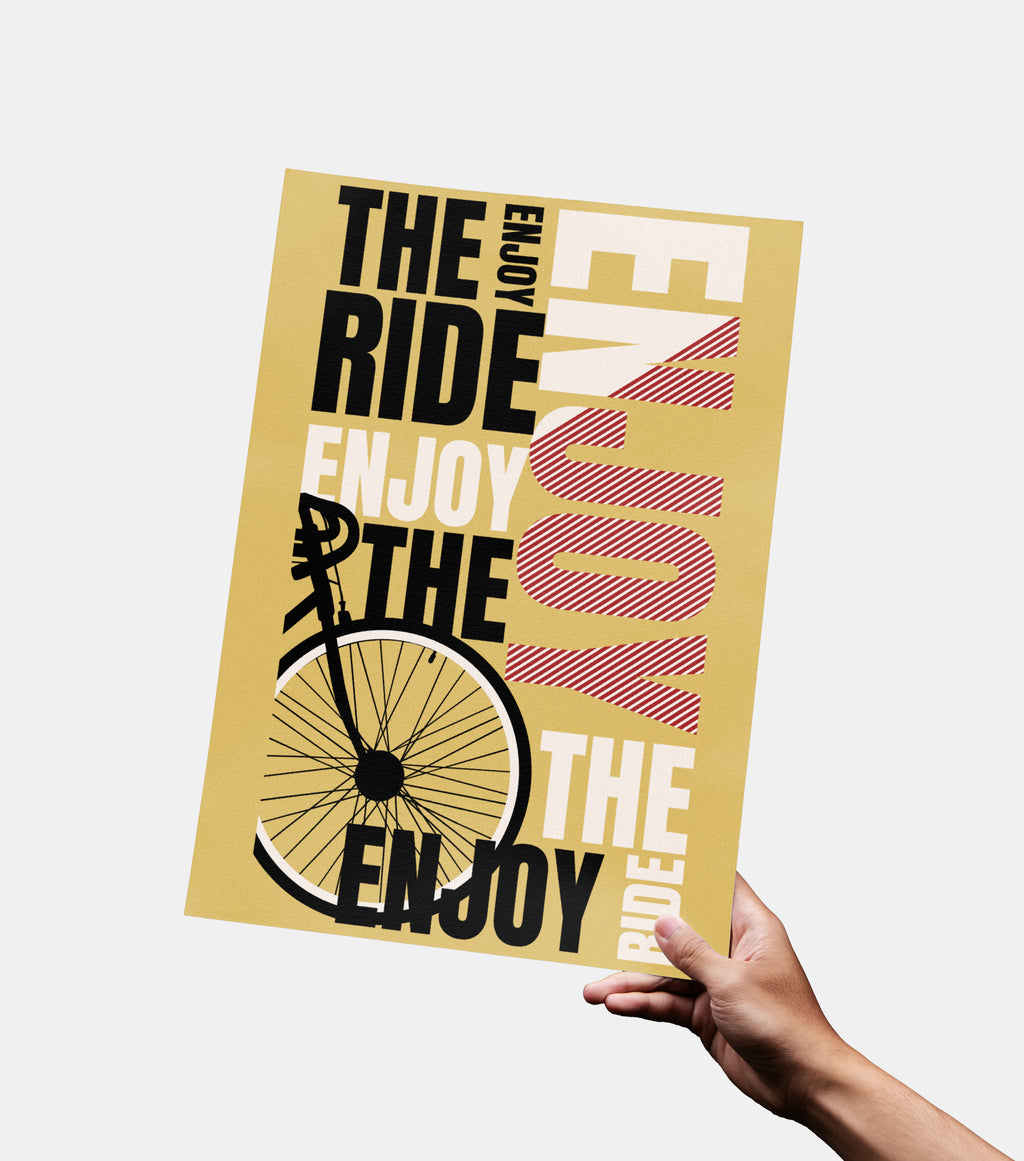 Hand holding a poster with a bicycle graphic and motivational text on a light background